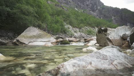 Calm-mountain-river-flowing-through-rocks,-low-angle-landscape-shot
