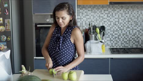 mujer cortando manzanas a bordo en la cocina