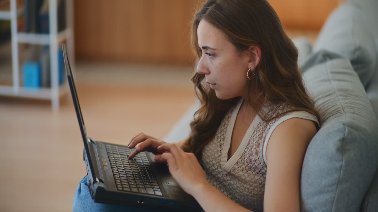 Woman on Sofa Working on Laptop