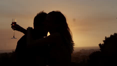 Romantisches-Paar-Trinkt-Und-Umarmt-Sich-Draußen-Bei-Sonnenuntergang,-Aufgenommen-Auf-R3D