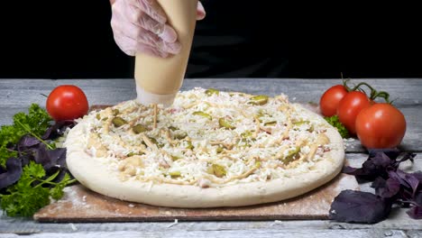 preparación de pizzas con salsa y ingredientes