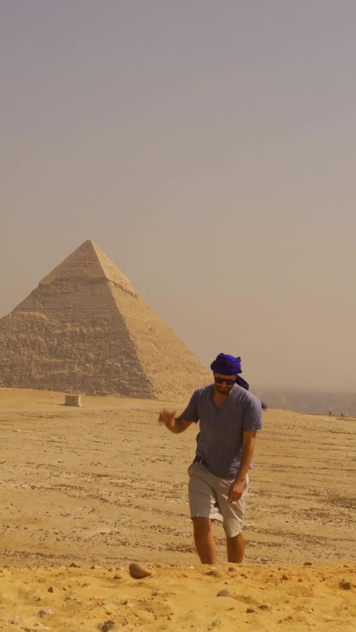 Uomo che cammina nel deserto con una piramide sullo sfondo
