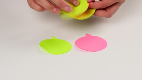 female hand sticks on a white background multicolored paper stickers in the shape of a cloud