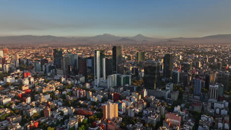 mexico city aerial v21 dolly in shot of central district capturing populous downtown cityscape with skyscrapers and mountainscape background at sunset - shot with mavic 3 cine - december 2021