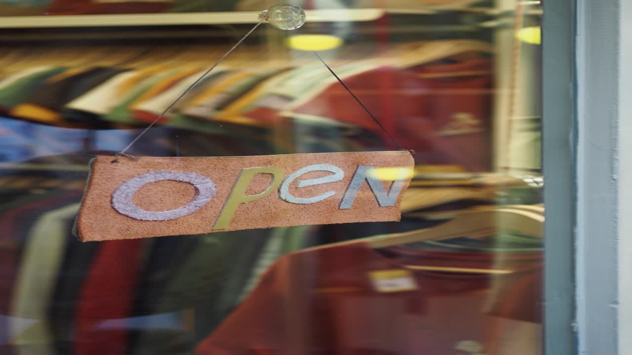 창문에 매달린 상점의 오픈 표지판