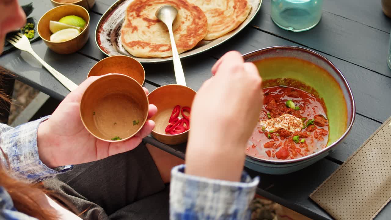 Woman enjoying Indian meal outdoors