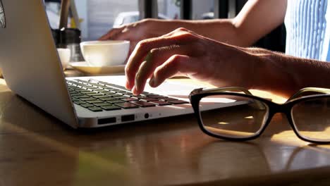 businesswoman using laptop while having coffee