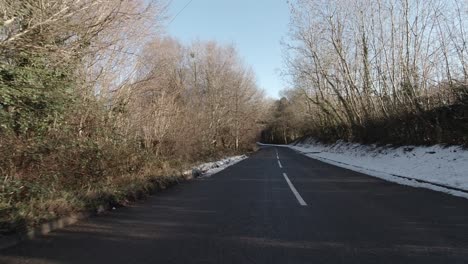 driving fast along snowy white rural snow covered secluded countryside road wilderness pov