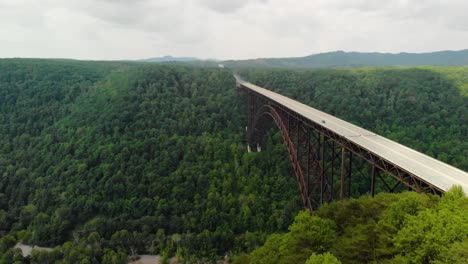 Parallax aerial drone shot over trees of New River Gorge Bridge in Fayetteville, WV