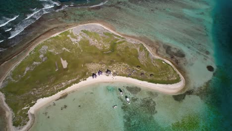 Cayo-vapor-in-los-roques-with-clear-turquoise-waters-and-boats,-aerial-view