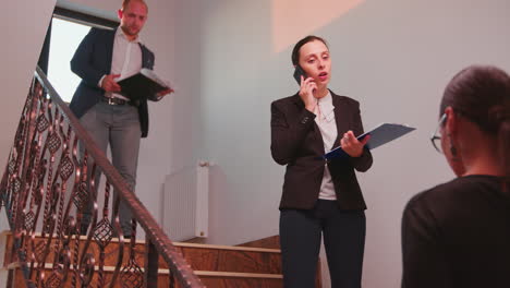 businesswoman speaking on phone standing on stairs