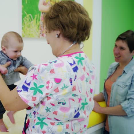 pediatrician examining child with parent mom. young mother with little children on the inspection of doctor in the clinic