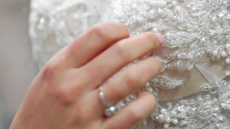 Close-up-fashion-designer-for-brides-in-his-Studio-pins-needles-lace-wedding-dress.-Seamstress-creates-an-exclusive-wedding-dress.-Secure-with-pins-and-needles-outline.-Small-private-business