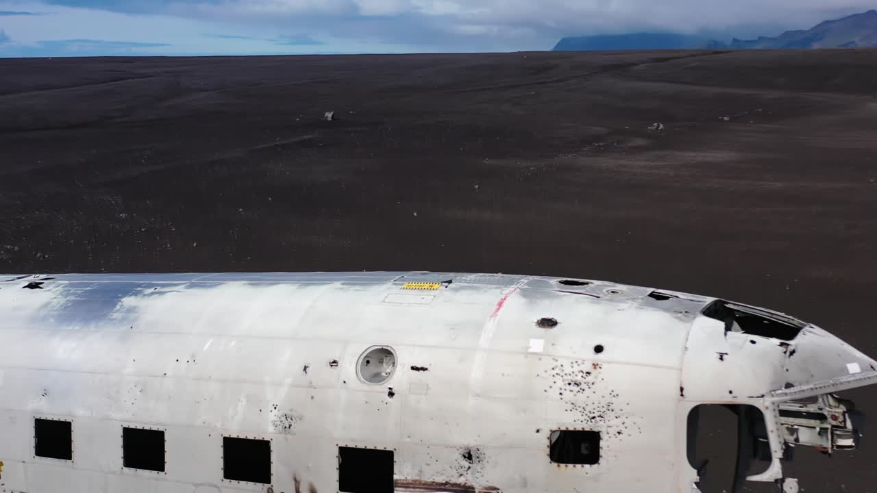 mujer caminando sobre un avión naufragado en islandia