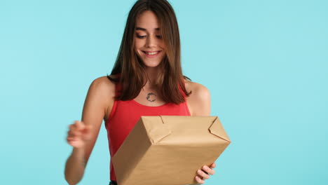 Caucasian-happy-woman-posing-in-front-of-camera-on-blue-background.