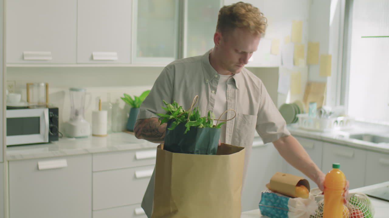 Man Unloading Groceries in Kitchen at Home