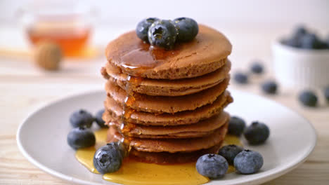 chocolate pancake stack with blueberry and honey on plate