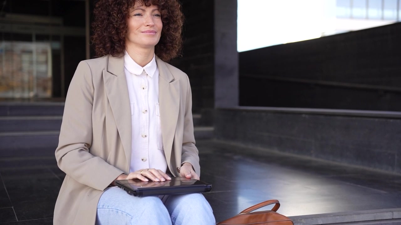 Una donna professionista attivamente impegnata nel suo lavoro mentre usa il suo laptop all'aperto.