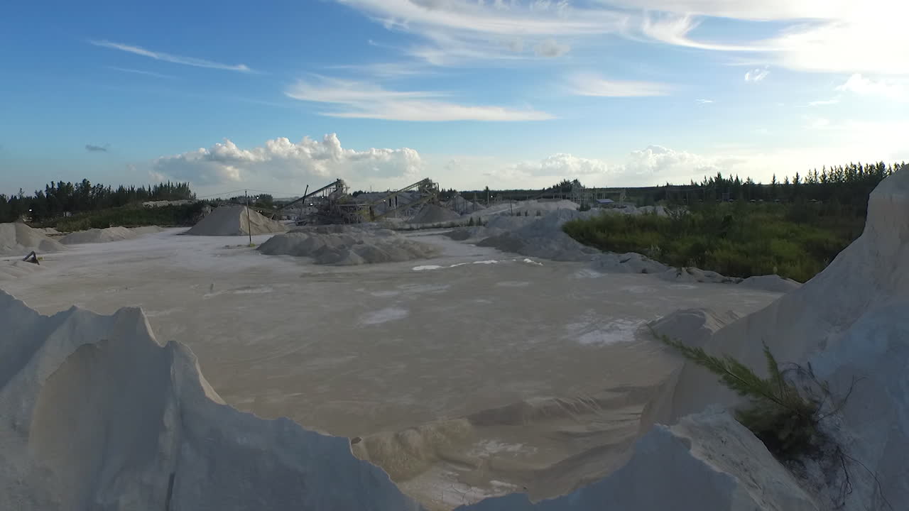 Drone reveals open pit sand quarry with conveyors and eroded mineral walls