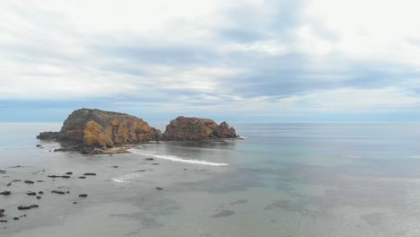 Aerial-shot-moving-forward-over-a-coastal-rock-formation-in-calm-seas-of-Australias-southern-ocean