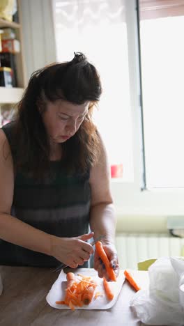 mujer pelando zanahorias en la cocina