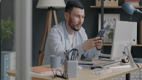 man working on computer and smartphone in office