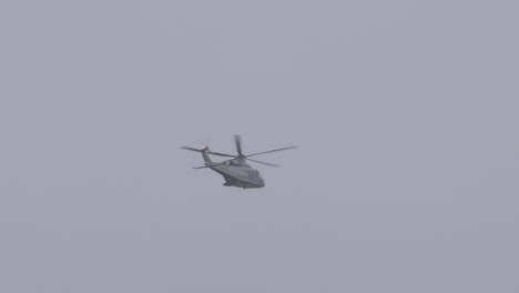 a grey helicopter against a cloudy sky