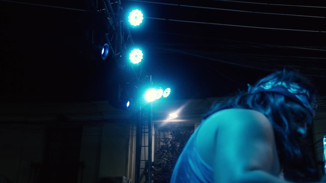 Camera moving from right to left side on the right side of a drummer playing a song in an outdoor concert