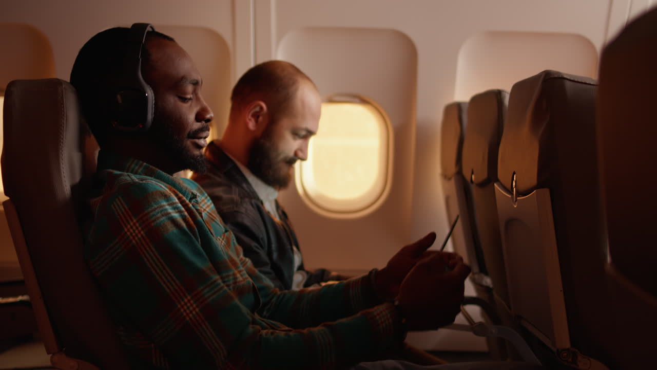Passeggero di sesso maschile che parla con l'assistente di volo sull'aeroplano