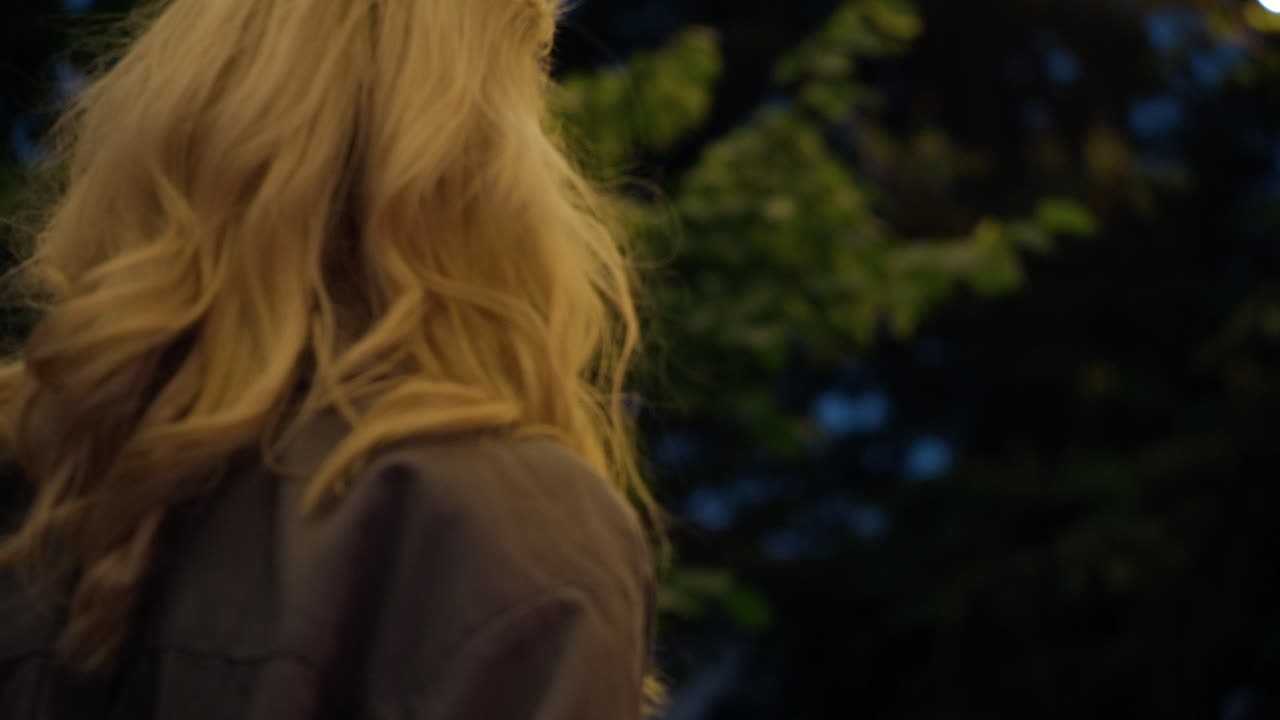 공원 도시 지역 불빛에서 혼자 저녁 도시를  ⁇ 는 금발 소녀.