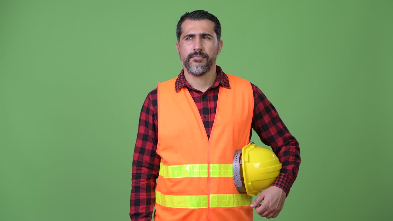 Handsome Persian bearded man construction worker pointing finger