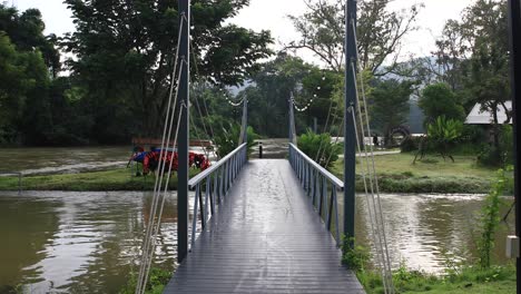 Symmetrische-Ansicht-4k-Einer-Stahlfußbrücke,-Die-Einen-Fluss-In-Thailand-überquert