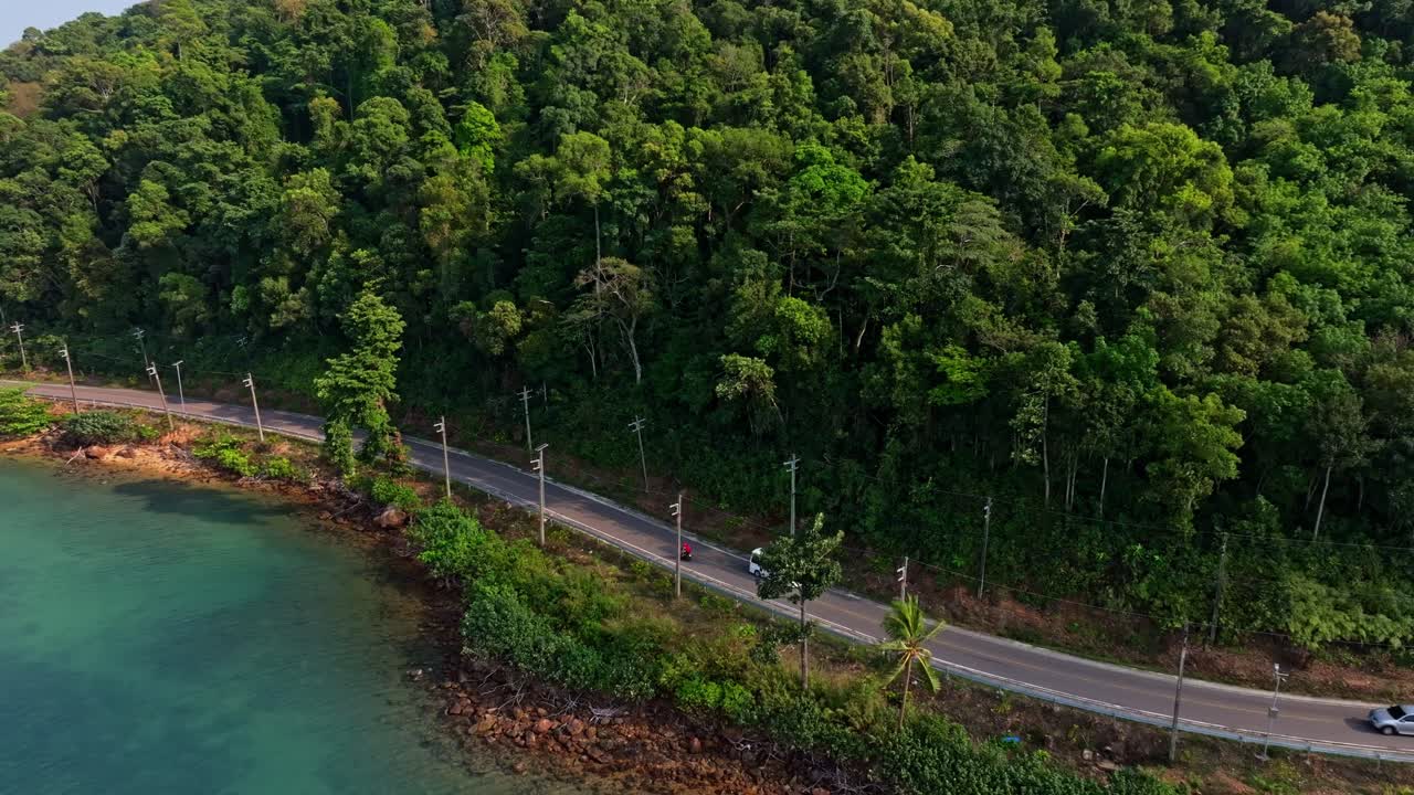 Tropikal kıyıyı saran virajlı yol, ormanlık kıyıya yakın arabalarla, Tayland
