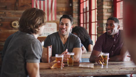 group of male friends meeting in sports bar making toast together