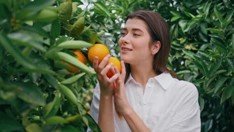 happy lady smell citrus fruit at nature closeup. woman enjoying orange aroma