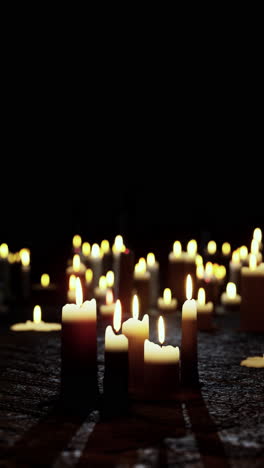 a collection of candles burning in the dark