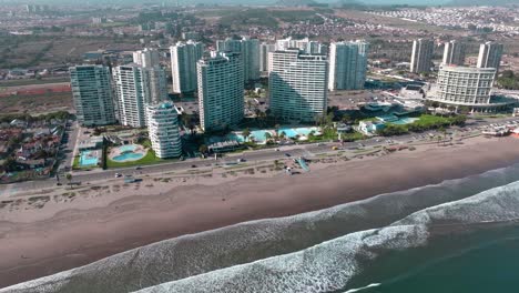 Aerial-orbit-of-exclusive-buildings-with-swimming-pool-and-ocean-view-on-a-sunny-day