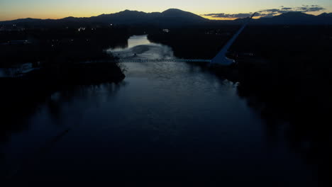 aerial footage panning up to reveal the sundial bridge in the dusk of sunset over the sacramento river in redding, california