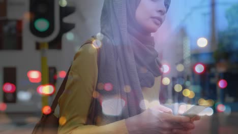 animation of asian woman in hijab using smartphone over cityscape