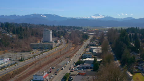 Wunderschöne-Drohnenansicht-Des-South-Fraser-Way-In-Abbotsford,-British-Columbia,-Während-Sich-Der-Verkehr-Auf-Der-Straße-Durch-Diese-Wachsende-Bergstadt-Bewegt