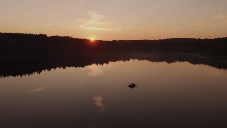 boat cruising the beautiful calm lake at sunset in rogowko, poland - wide shot panning