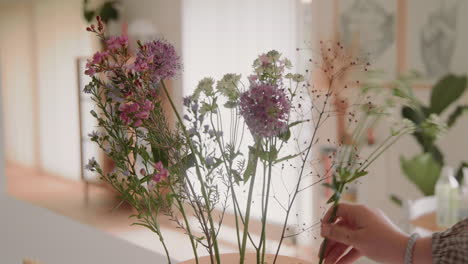 Young-female-decorating-Vase-With-fresh-Flowers,-Floral-Bouquet-On-The-Table-Inside-at-Home-Close-Up-4K