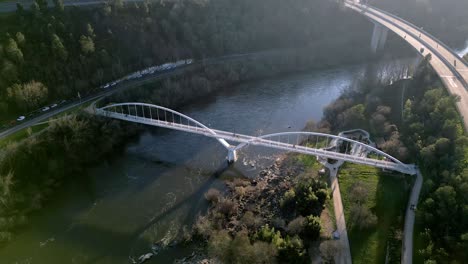 toma aérea sobre un puente en el río miño en españa, carretera, gran vegetación, horizonte con montañas y cielo azul