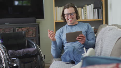 Feliz-Hombre-Discapacitado-Caucásico-Sentado-En-Un-Sofá-En-La-Sala-De-Estar-Usando-Una-Tableta