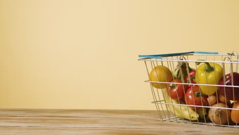 studio shot of basic fresh fruit and vegetable food items in supermarket wire shopping basket 3