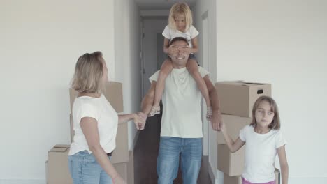 Two-happy-girls-and-their-mom-leading-dad-with-closed-eyes