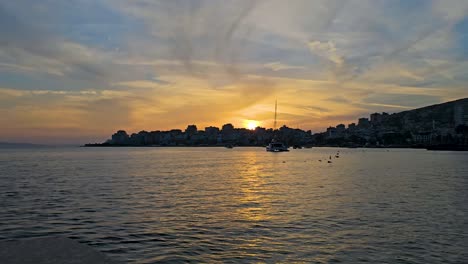 mediterranean coastal city of saranda, sunset over the port and serene sea bay – a captivating journey through dusk