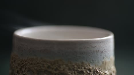 macro of a rising smoke over an edge of ceramic glass