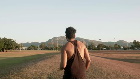 Chico-Indio-Corriendo-Y-Entrenando-Para-Hacer-Ejercicio-Cardiovascular-En-Un-Parque-Público-Durante-La-Puesta-De-Sol