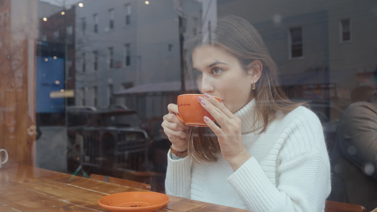 Woman enjoying coffee at a cafe window